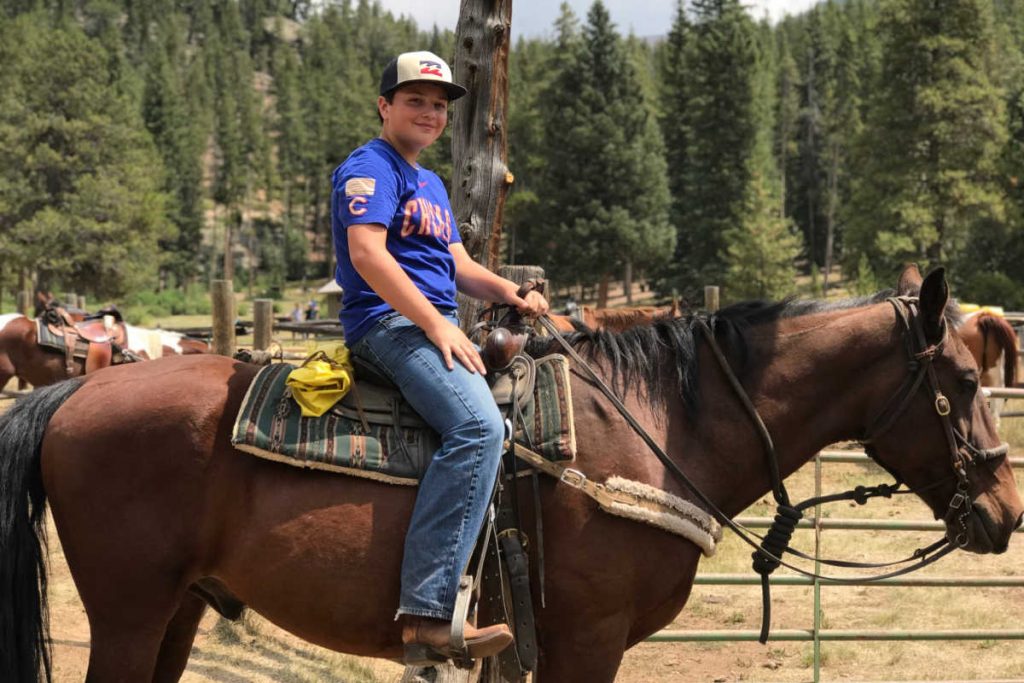 Kid riding horse Tumbling River dude ranch vacation
