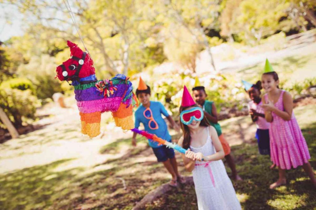 Kids outside lining up for a pinata bash.