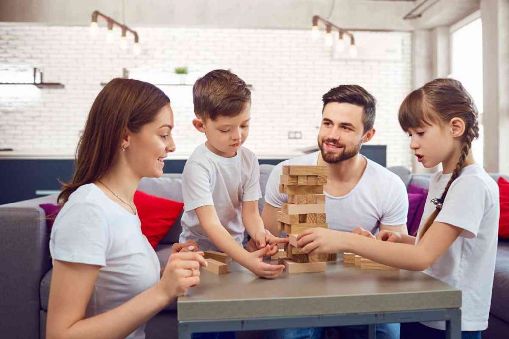 Family playing jenga at a living room table.