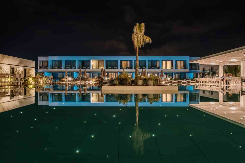 Gennadi Grand Resort, Rhodes at nighttime with a view of the pool and dining area.