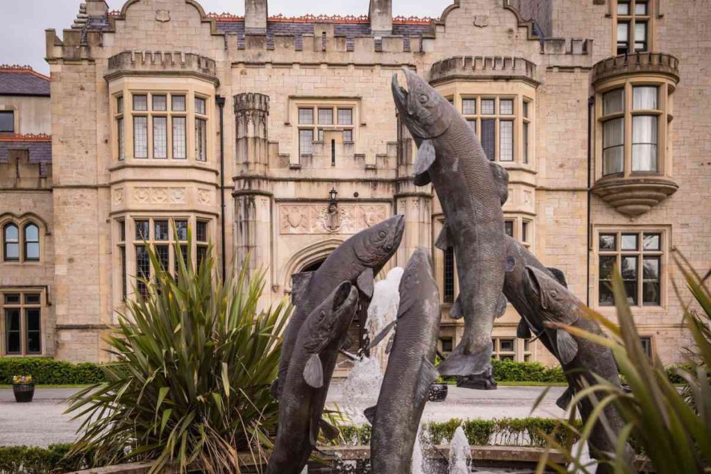 Front view of the Lough Eske Castle, with fish statues in front.